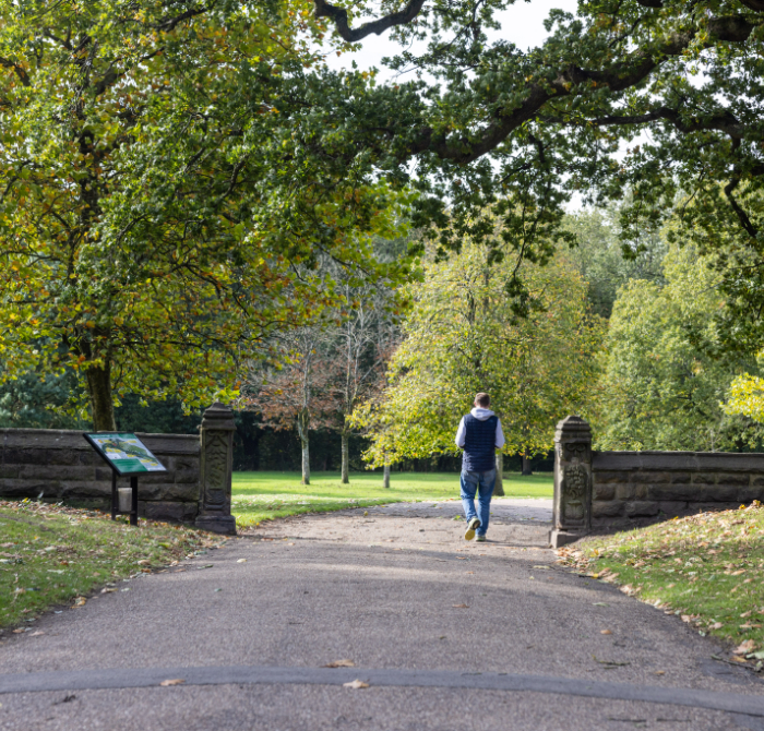 Man walking through gardens at Astley Hall