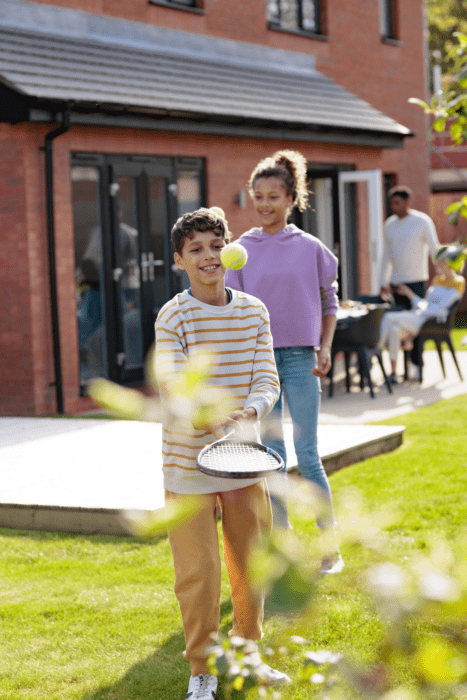 children playing tennis outside of an Anwyl home